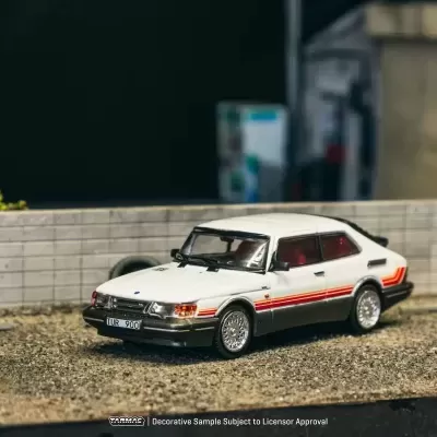 Miniatura de carro branco com riscas vermelhas num cenário exterior