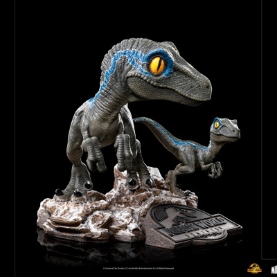 Miniaturas de dinossauros velociraptors cinzentos com riscas azuis em base rochosa com placa Jurassic Park
