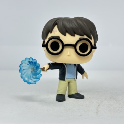 Boneco Funko Pop com cabelo castanho, óculos redondos e varinha com efeito azul
