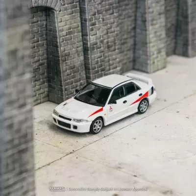 Miniatura de carro de corridas Mitsubishi branco com detalhes vermelhos num cenário de cimento e tijolo