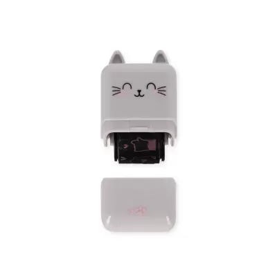Carimbo de plástico cinzento em forma de gato com rolo de estampas e tampa com pegadas.