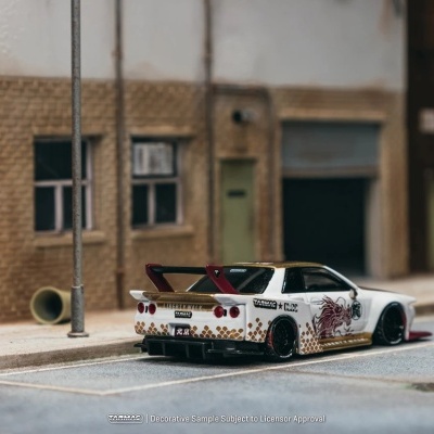 Miniatura de carro desportivo branco com detalhes dourados e vermelhos num cenário urbano