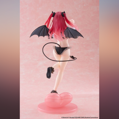 Figura colecionável com asas e cauda de morcego sobre base rosa em forma de coração.