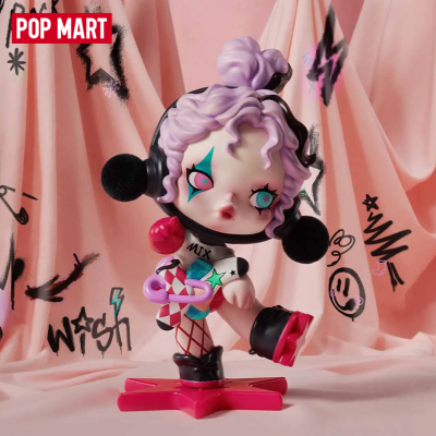 Estatueta colorida com cabelo lilás e roupa decorada com base rosa e cortina de fundo cor de rosa com desenhos pretos.