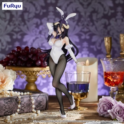 Figura colecionável feminina em traje de coelhinha branco com meias de rede pretas e acessórios em cenário decorativo.