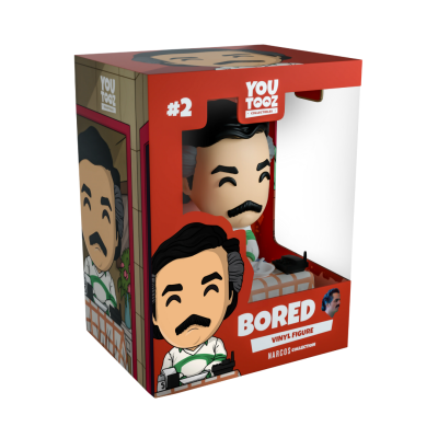 Caixa vermelha com figura de vinil de personagem com cabelo preto e bigode sentado numa cadeira