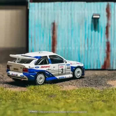 Miniatura de carro de rali branco e azul com marcas e números e fundo de parede azul