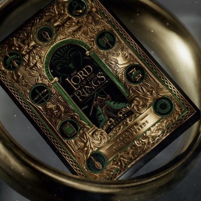 Livro Lord of the Rings dourado e verde refletido num anel dourado