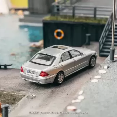 Miniatura de carro prata sedan em miniatura junto à água