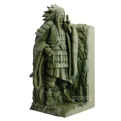 Estátua verde musgo de personagem com armadura e cabelo espetado junto a parede rochosa