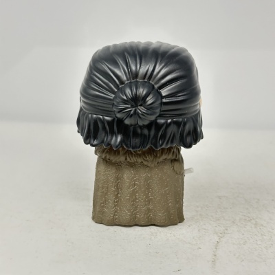 Figura de brinquedo com cabelo preto preso em coque e vestido bege com padrão floral