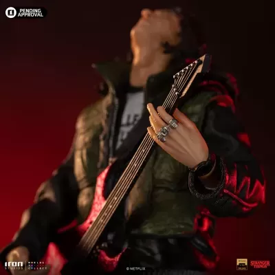 Figura de ação com guitarra vermelha e preta e casaco verde e preto