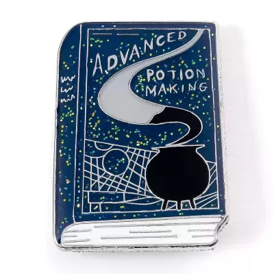 Pin metálico em forma de livro azul com caldeirão e texto