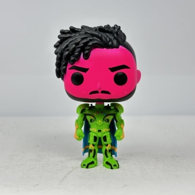 Figura colecionável Funko Pop com cabeça rosa, cabelo preto e roupa verde com capa azul.