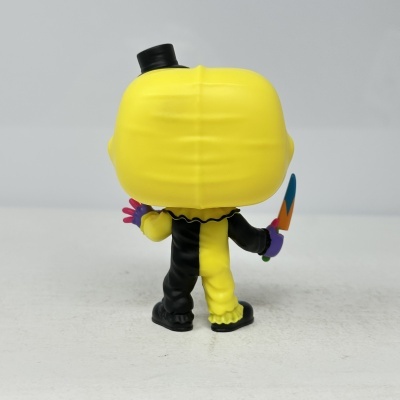 Figura colecionável com corpo metade preto, metade amarelo, cabeça amarela e cartola preta vista de costas