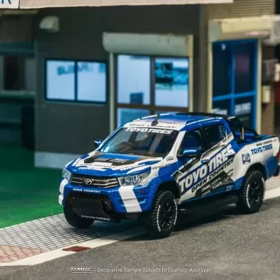 Miniatura de pickup Toyota azul, branco e preto com texto TOYOTIRES OPEN COUNTRY