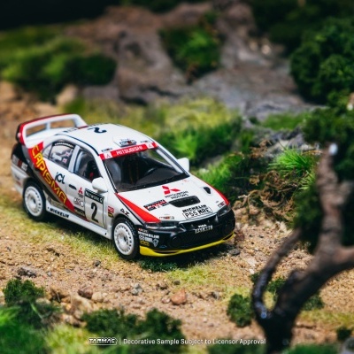 Miniatura de carro de rali Mitsubishi branco em terreno com vegetação