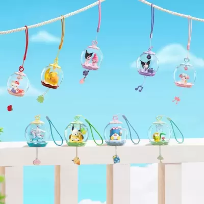 Cúpulas transparentes com personagens coloridos penduradas e alinhadas sobre cerca branca, céu azul com nuvens ao fundo.