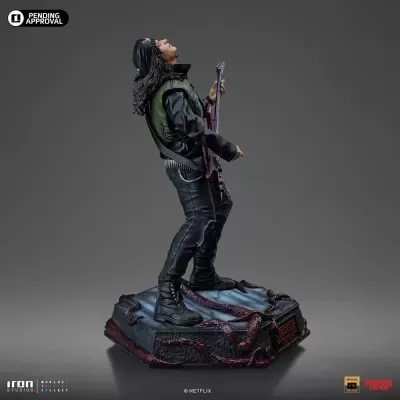 Estátua masculina com guitarra sobre base decorativa preta e vermelha