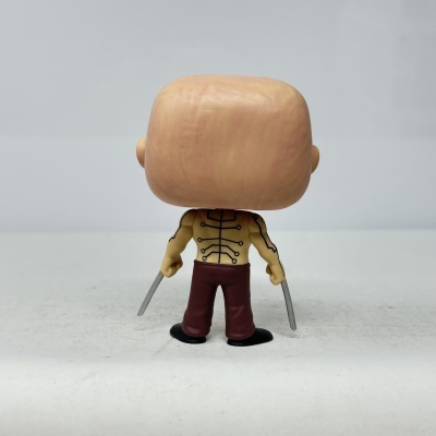 Figura colecionável de plástico com lâminas e tatuagens vista de trás