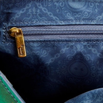 Fecho de correr dourado em bolsa azul escura com padrão decorativo