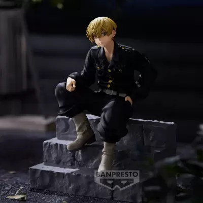 Figura colecionável de personagem masculino loiro com uniforme preto sentado em pedestal cinzento