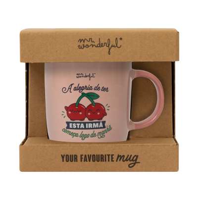 Caneca rosa com ilustração de duas cerejas felizes e texto em português, dentro de embalagem de cartão castanho.
