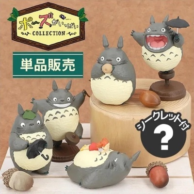 Coleção de miniaturas Totoro cinzentas em várias poses com bolotas e base de madeira