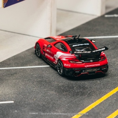 Carro de corrida de brinquedo vermelho e preto em pista de corrida em miniatura