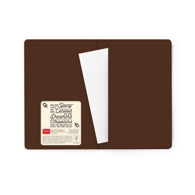 Caderno aberto com capa interior castanha e etiqueta com texto motivacional.