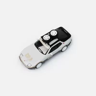 Carro de brinquedo branco com texto dourado no capot e rodas no tejadilho