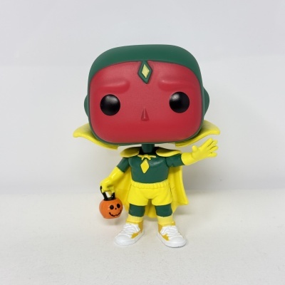 Figura colecionável Funko Pop de personagem com rosto vermelho e roupa amarela e verde segurando balde de abóbora