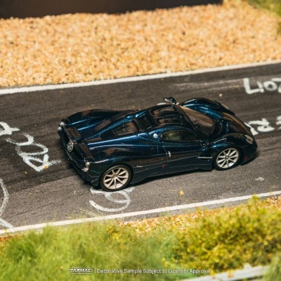 Miniatura de carro desportivo azul metálico numa pista de corrida em miniatura.