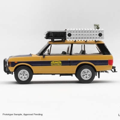 Miniatura de automóvel todoterreno amarelo com faixa preta e equipamento no tejadilho