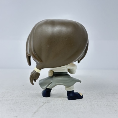 Boneco de brinquedo visto de trás com cabelo castanho e roupa branca