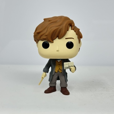 Figura Funko Pop com cabelo castanho e roupa cinzenta e amarela segurando varinha e papel