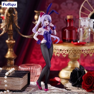 Estatueta de personagem anime com roupa de coelho roxa e meias pretas com decoração ao fundo