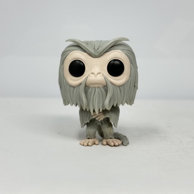 Figura colecionável cinza e bege com olhos grandes e pretos