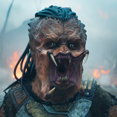 Máscara de monstro com presas e dreadlocks, fogo ao fundo