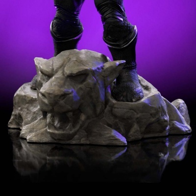 Base decorativa com cabeça de felino cinzento e pernas negras em fundo roxo