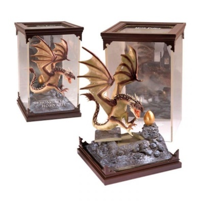 Figura decorativa de dragão com asas castanhas e base rochosa cinzenta com ovo dourado