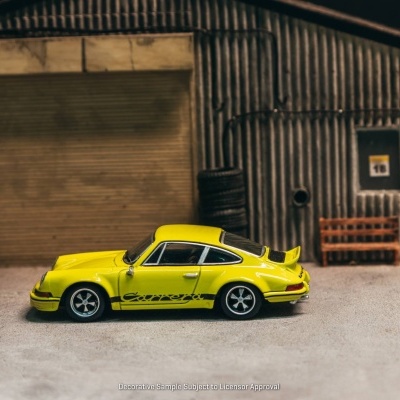 Miniatura de carro desportivo amarelo com texto Carrera na lateral em cenário de garagem metálica