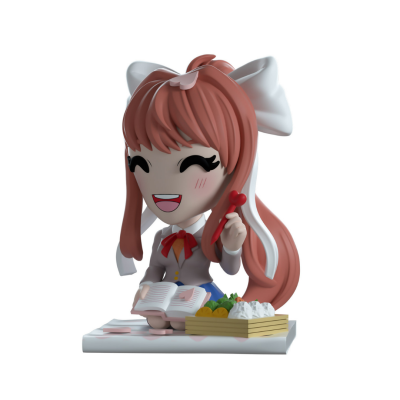 Figura colecionável com personagem de cabelo castanho e roupa escolar sentada com livro e comida em caixa de madeira