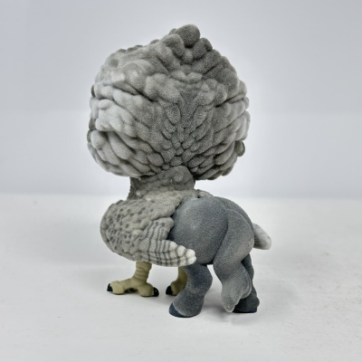 Figura aveludada cinzenta de criatura híbrida com cabeça grande e corpo pequeno