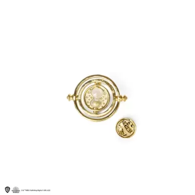 Broche dourado com efeito giratório e pequeno objeto redondo dourado em fundo branco