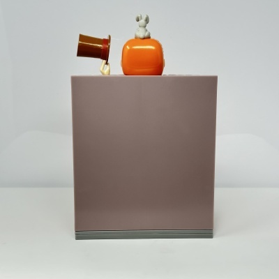 Caixa bege claro com figura branca de coelho e bule vermelho em cima