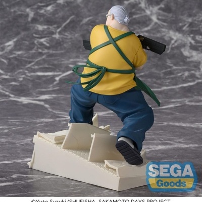 Figura colecionável de personagem com camisa amarela e avental verde segurando arma