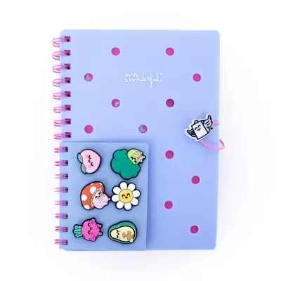 Caderno lilás com espiral rosa e pins coloridos de fruta e flor