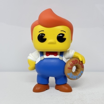 Figura de vinil com cabeça amarela, cabelo laranja e donut com texto