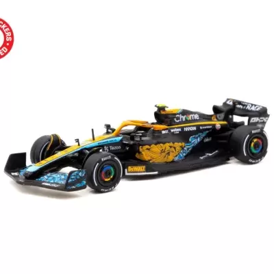 Miniatura de carro de Fórmula 1 preto e amarelo com padrões florais e textos de marca em fundo branco